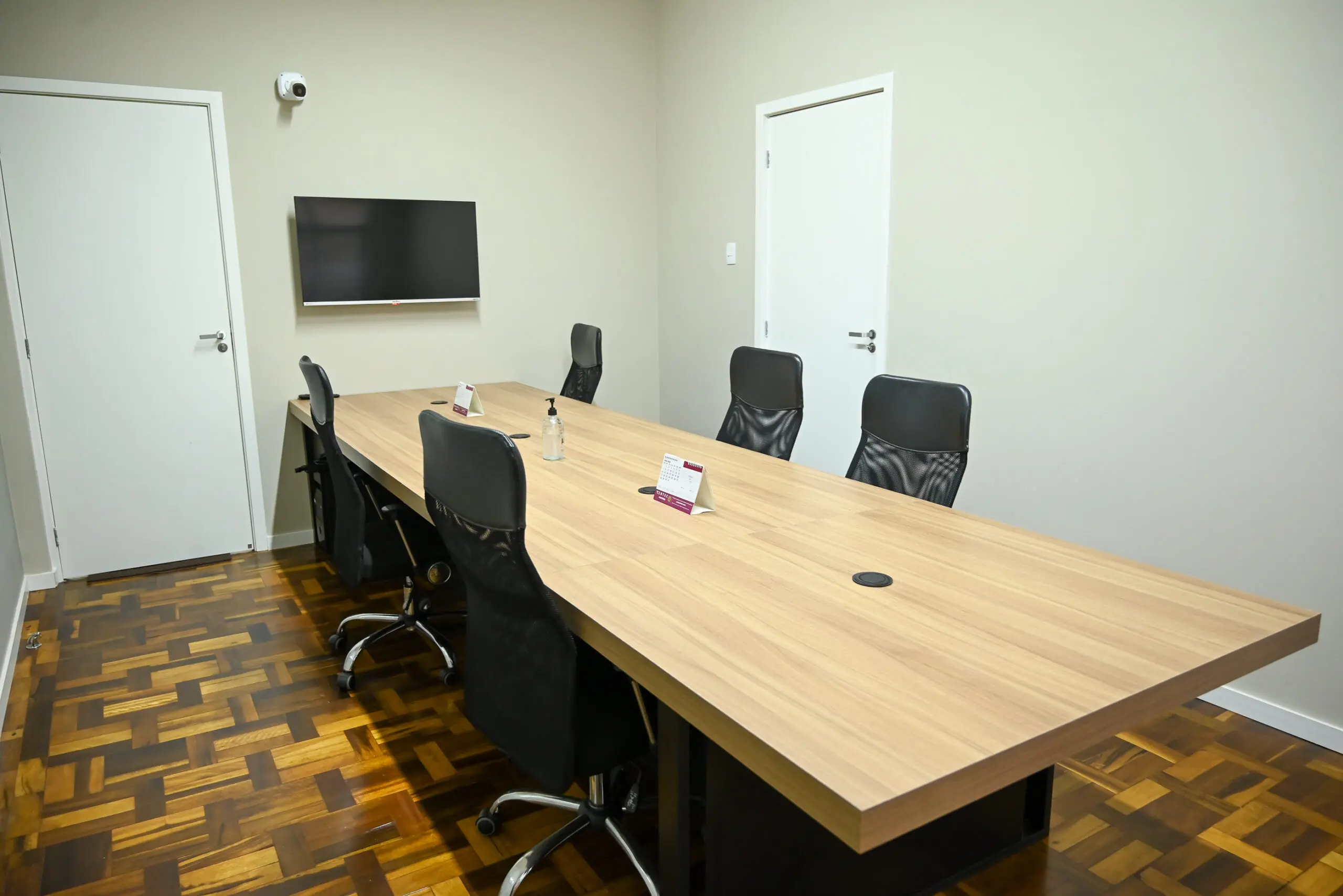 Sala de Reunião com TV — Sala de reunião equipada com TV e sistema de som de alta qualidade para apresentações, além de quadros de vidro para trabalho colaborativo. Indicada para alinhamentos internos e recepção de clientes.